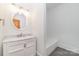 Modern bathroom with white vanity, marble countertop, and bathtub at 414 W Harvie Ave, Gastonia, NC 28052
