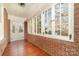 Sunroom featuring brick walls, wood floors, and multiple windows at 414 W Harvie Ave, Gastonia, NC 28052