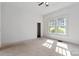 Spacious bedroom with neutral carpet, bright windows, and a ceiling fan at 6037 Pleasant Grove Rd, Charlotte, NC 28216