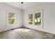 Sunlit bedroom with large windows offering outdoor views and wood-look vinyl flooring at 6037 Pleasant Grove Rd, Charlotte, NC 28216