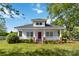 Charming two-story home with a red door and a cozy front porch at 6037 Pleasant Grove Rd, Charlotte, NC 28216