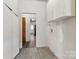 Bright hallway with white storage cabinets and wood-look tile flooring leading to other rooms at 6037 Pleasant Grove Rd, Charlotte, NC 28216