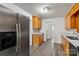 Well-lit kitchen featuring wood cabinets, white countertops, and a stainless steel refrigerator at 6037 Pleasant Grove Rd, Charlotte, NC 28216