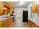 Galley-style kitchen featuring black appliances and wood cabinetry at 6037 Pleasant Grove Rd, Charlotte, NC 28216