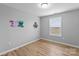 Well-lit bedroom with light-colored walls, hardwood floors, window with blinds, and neutral paint at 6101 Bunn Simpson Rd, Marshville, NC 28103