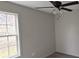 Bedroom with a ceiling fan, grey flooring, and a window offering natural light at 629 S Caldwell St, Salisbury, NC 28144