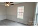 Living room showcasing paneled walls, grey flooring, and a ceiling fan at 629 S Caldwell St, Salisbury, NC 28144