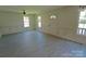 Bright living room featuring fresh paint, a ceiling fan, and large windows for ample natural light at 629 S Caldwell St, Salisbury, NC 28144