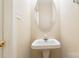 Powder room features a pedestal sink, oval mirror, and neutral walls at 7117 Flying Scotsman Dr, Charlotte, NC 28213