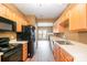 Well-equipped kitchen with wooden cabinets, laminate flooring, and stainless steel appliances, seamlessly connected to the living area at 7117 Flying Scotsman Dr, Charlotte, NC 28213