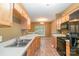 Well-lit kitchen featuring stainless steel appliances, wooden cabinets, laminate flooring, and an open layout at 7117 Flying Scotsman Dr, Charlotte, NC 28213