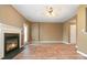 Spacious living room featuring a fireplace, ceiling fan, wood-look floors, and natural light from windows and the door at 7117 Flying Scotsman Dr, Charlotte, NC 28213
