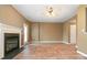 Spacious living room with a fireplace, wood-look floors, ceiling fan and natural light from windows and door at 7117 Flying Scotsman Dr, Charlotte, NC 28213