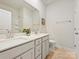 Bathroom with dual sinks, white cabinets, and a large mirror, offering a clean and bright space at 7522 Porrera St, Charlotte, NC 28214