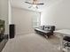Comfortable bedroom featuring neutral carpet, a ceiling fan, and a full-size futon sofa at 7522 Porrera St, Charlotte, NC 28214
