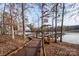Picturesque view of a wooden walkway leading to a boat dock on a serene lake at 7522 Porrera St, Charlotte, NC 28214