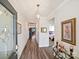 Inviting hallway with wood-look floors, decorative lighting, and views into other living spaces at 7522 Porrera St, Charlotte, NC 28214