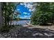 Scenic lake view featuring a wooden dock, clear blue waters, and lush green trees, perfect for lakeside living at 7522 Porrera St, Charlotte, NC 28214