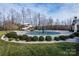 Community pool covered for the off-season, surrounded by lush landscaping and trees, promising summertime fun at 7522 Porrera St, Charlotte, NC 28214