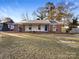 Brick ranch house with covered porch and landscaped yard at 1005 Woodland Dr, Gastonia, NC 28054