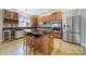 Modern kitchen boasting stainless steel appliances, a granite countertop island, and hardwood floors at 10319 Barrands Ln, Charlotte, NC 28278