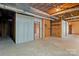 Unfinished basement with exposed piping and studs provides a glimpse of the home's inner workings at 107 Cambridge Rd, Huntersville, NC 28078