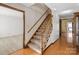 A carpeted staircase with wooden banisters leads to the upper level of the home at 107 Cambridge Rd, Huntersville, NC 28078