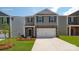 Charming two-story home featuring gray siding, stone accents, a two-car garage, and a well-maintained front yard at 1427 5Th Street Ne Dr, Hickory, NC 28601