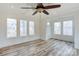 Bright living room with hardwood floors, large windows, and a ceiling fan at 1505 S Ridge Ave, Kannapolis, NC 28083