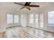 Bright living room with hardwood floors, large windows, and a ceiling fan at 1505 S Ridge Ave, Kannapolis, NC 28083