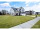 Two story house with gray siding, stone accents, and a white garage door at 3070 Swallowtail Ln, Kannapolis, NC 28027