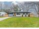 Charming single-story home with a well-manicured lawn, stone accents and modern gray and white exterior paint at 531 Manhasset Rd, Charlotte, NC 28209