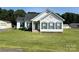 Charming single-story home featuring a well-manicured front yard, red door, and classic shutters at 6328 W Nc 10 Hwy, Hickory, NC 28602