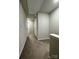 Upstairs hallway with neutral carpet and white walls at 7132 Somerford Rd, Charlotte, NC 28215