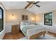 Cozy bedroom with wood floors, sconce lighting, and a tranquil view from the black framed windows at 125 Chestnut Tree Rd, Mooresville, NC 28117