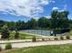 A pristine tennis court surrounded by lush greenery and professional lighting at 1605 Appledale Ct # 116, Fort Mill, SC 29715