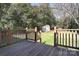 Backyard features a deck with wooden railings, a grassy lawn, and a storage shed at 1721 Edgewater Dr, Charlotte, NC 28210