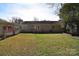 Large grassy backyard featuring the home's exterior, a deck, and a partial view of an adjacent covered patio at 1721 Edgewater Dr, Charlotte, NC 28210