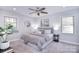 Inviting bedroom with large windows, soft carpet, neutral decor, and ceiling fan at 1721 Edgewater Dr, Charlotte, NC 28210