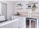 Close-up of dining room with a wine cooler cabinet, floating shelves, and decorative tile backsplash at 1721 Edgewater Dr, Charlotte, NC 28210