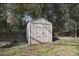 Storage shed with double doors, situated in a shaded area of the yard at 1721 Edgewater Dr, Charlotte, NC 28210