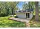 Rear view of backyard building with siding and sliding glass door with concrete porch and natural landscaping at 1801 Windsor Dr, Lancaster, SC 29720