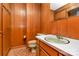 Bathroom with toilet, sink, and wood paneled walls at 1801 Windsor Dr, Lancaster, SC 29720