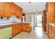 Kitchen with wood cabinets, tile floor, and access to backyard at 1801 Windsor Dr, Lancaster, SC 29720