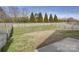 View of a fenced-in backyard featuring a sloping lawn and mature trees at 2001 Yellow Daisy Dr, Matthews, NC 28104