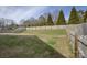 Large backyard with a wood fence, grassy areas, and mature trees at 2001 Yellow Daisy Dr, Matthews, NC 28104