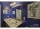 Bathroom with double sinks, a large mirror, and stylish blue walls at 2001 Yellow Daisy Dr, Matthews, NC 28104