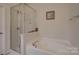 Bright bathroom featuring a soaking tub with shower and built-in toiletry shelf at 2001 Yellow Daisy Dr, Matthews, NC 28104