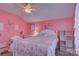 Pink bedroom with matching decor, a ceiling fan, and a window dressed in light curtains at 2001 Yellow Daisy Dr, Matthews, NC 28104