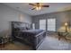 Comfortable bedroom with a ceiling fan, bedside table, and natural light from the windows at 2001 Yellow Daisy Dr, Matthews, NC 28104